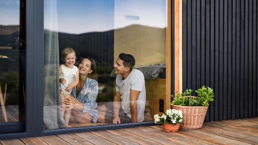 young family looking outside through window