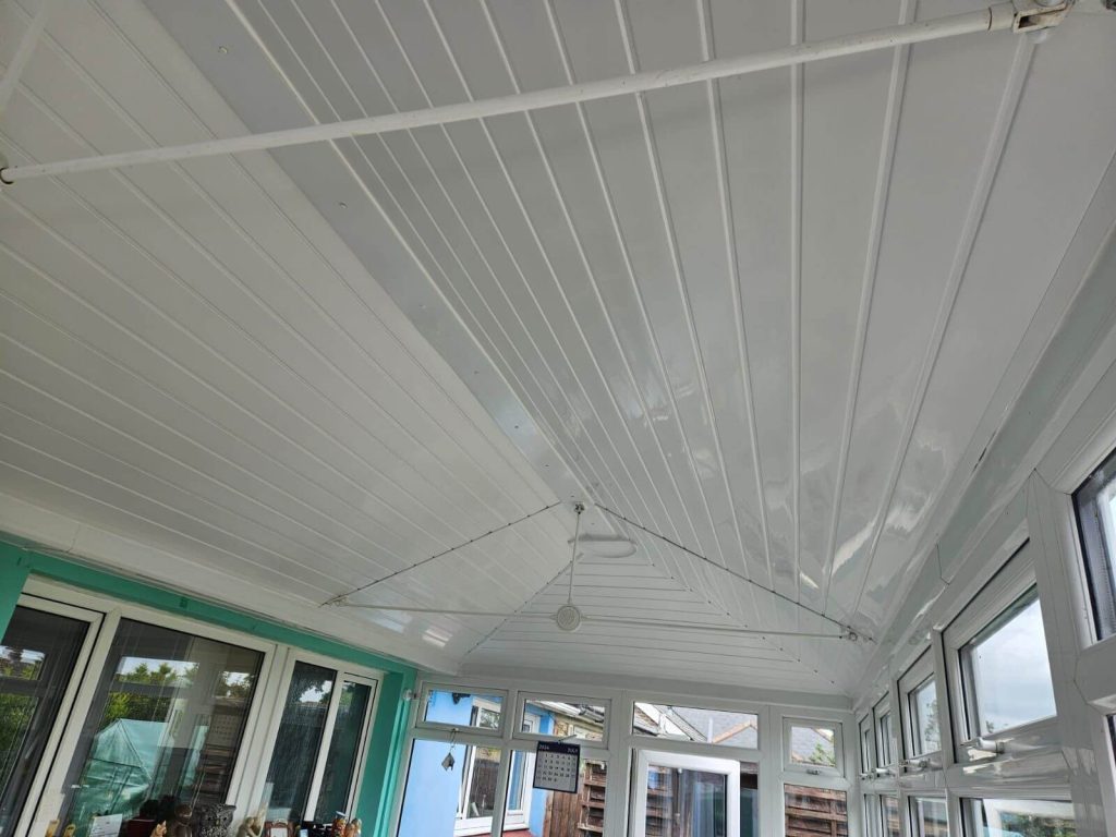 White-paneled conservatory ceiling with a pitched roof design.