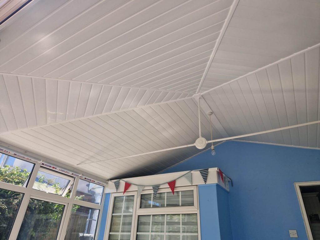 White-paneled conservatory ceiling with a pitched roof design.